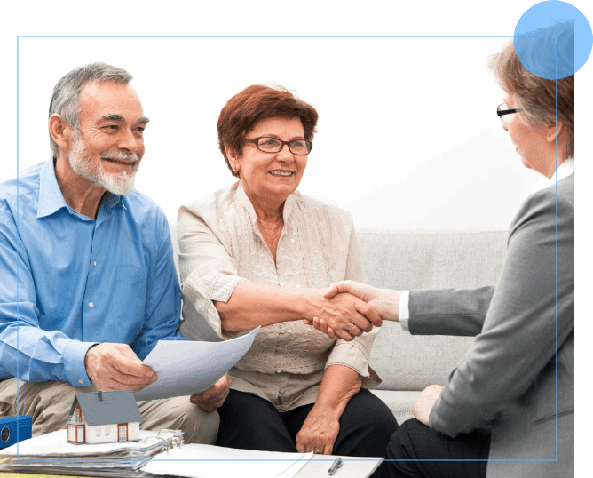 A group of people sitting around a table shaking hands.